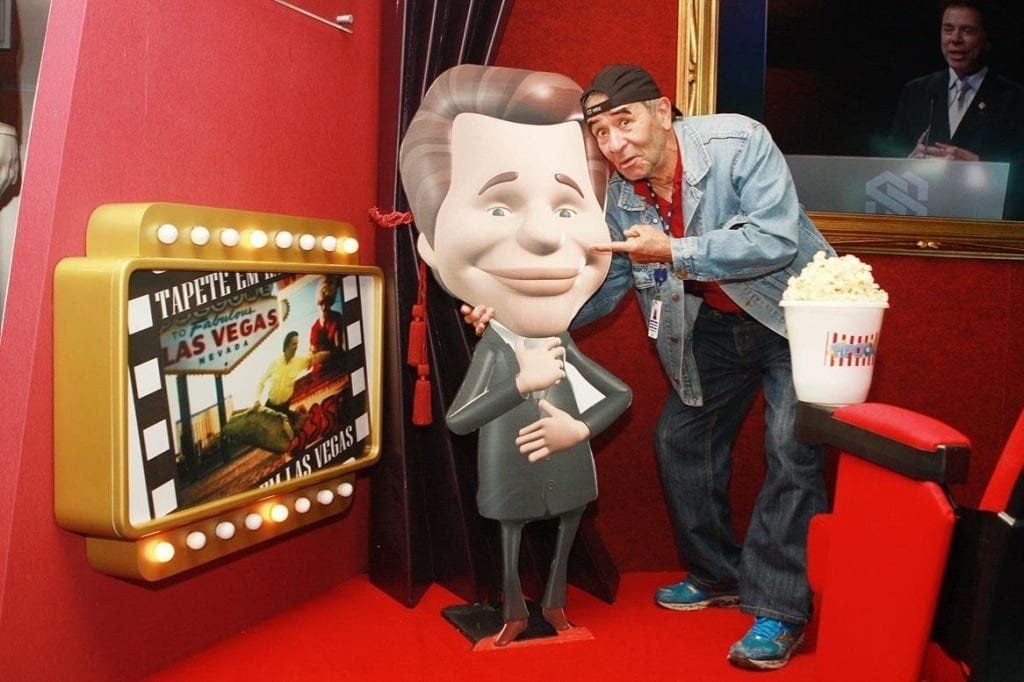 ivo holando ao lado de figura do silvio santos